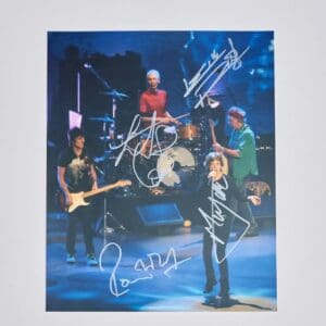 Band performing live, autographed concert photograph.