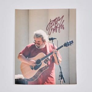 Man playing guitar with microphone stand nearby.