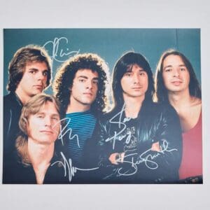 Five men posing, autographed band photo.