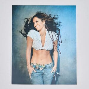 Smiling woman with flowing hair and jeans.