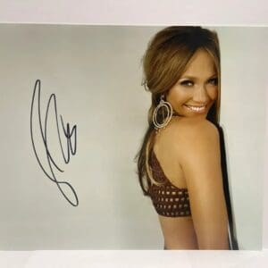 Smiling woman with signature on photograph.