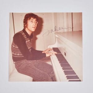 Person playing piano, wearing glasses and sweater.