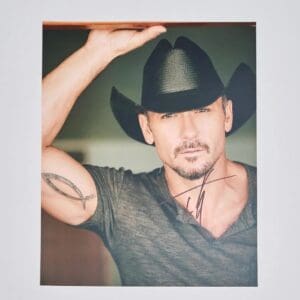 Man in cowboy hat with arm tattoo.