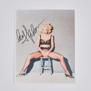 Blonde woman sitting on stool in lingerie.