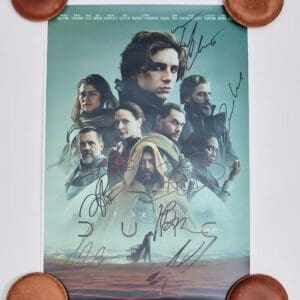 Movie poster with signatures and round objects.