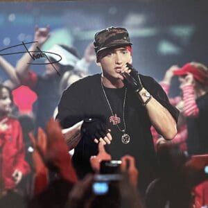 Rapper performing on stage with crowd cheering.