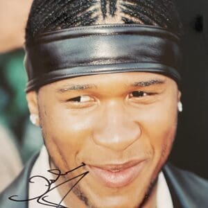 Smiling man with braids and headband.