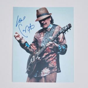 Guitarist playing electric guitar, wearing a hat.