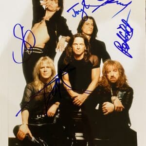 Band members posing with autographs on photo.