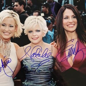 Three women smiling at an event.