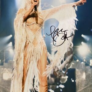 Performer singing on stage in feathered outfit.