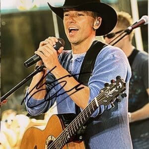 Singer performing on stage with guitar.