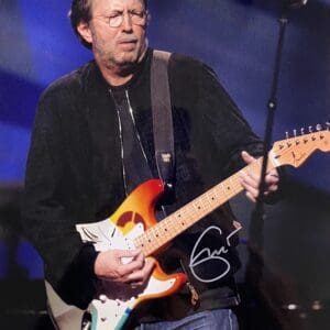 Musician playing electric guitar on stage.