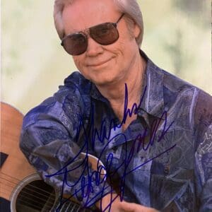 Man with sunglasses holding a guitar.