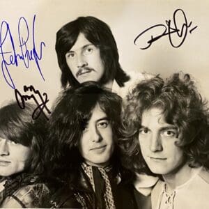 Four men with autographs on photo.