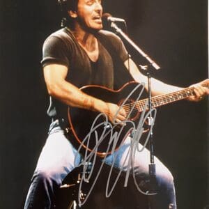 Singer performing with guitar on stage.