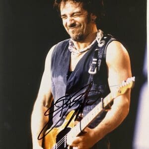 Musician playing electric guitar on stage.