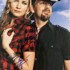 Man and woman posing outdoors, signed photo.