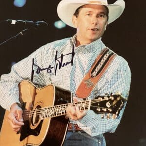 Man in cowboy hat playing acoustic guitar.