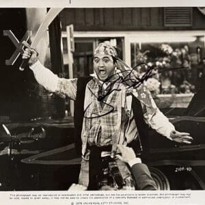 Man dressed as pirate holding sword, surprised.