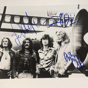 Band standing in front of airplane, autographed.