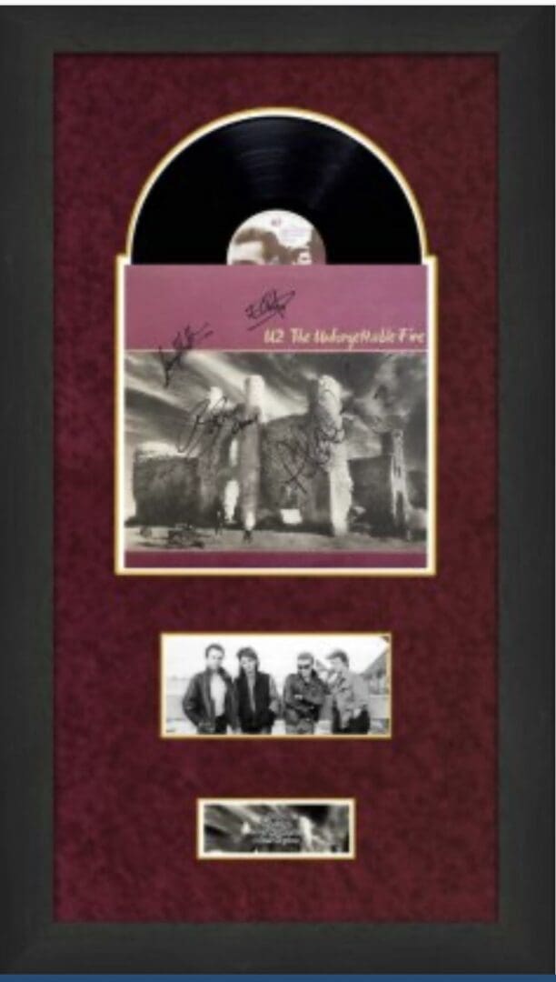 Framed vinyl record with band photographs.