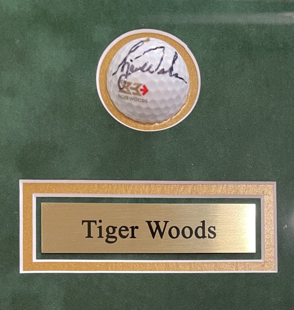Signed golf ball with "Tiger Woods" plaque.