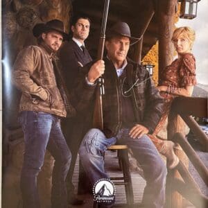 Four people posing in rustic setting.