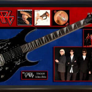 Framed guitar and band memorabilia display.