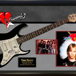 Framed guitar with band photos and logos.