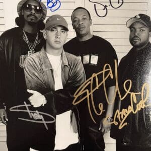 Four men posing with autographs on photo.