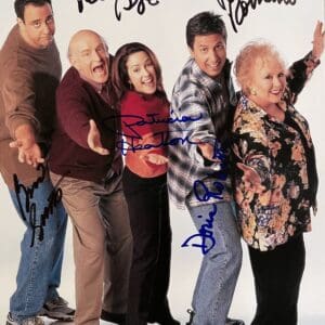 Five people posing with autographs on photo.