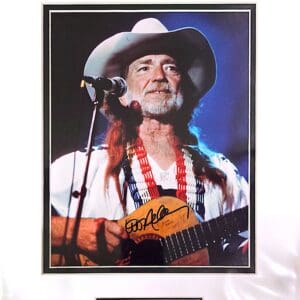 Singer with guitar and cowboy hat performing.