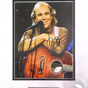 Man smiling with guitar on stage.