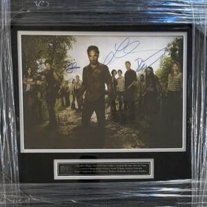 Framed autographed photo with multiple people.