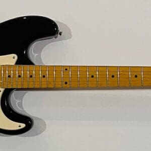 Black electric guitar with wooden neck.