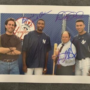 Four men posing in Yankees gear, smiling.