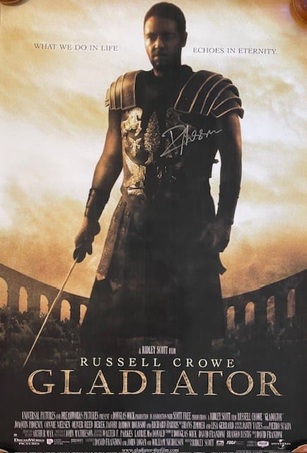 Movie poster of a gladiator in armor.