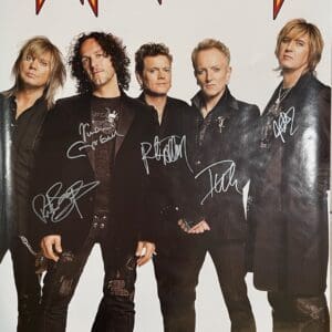 Band members with signed "Def Leppard" poster.