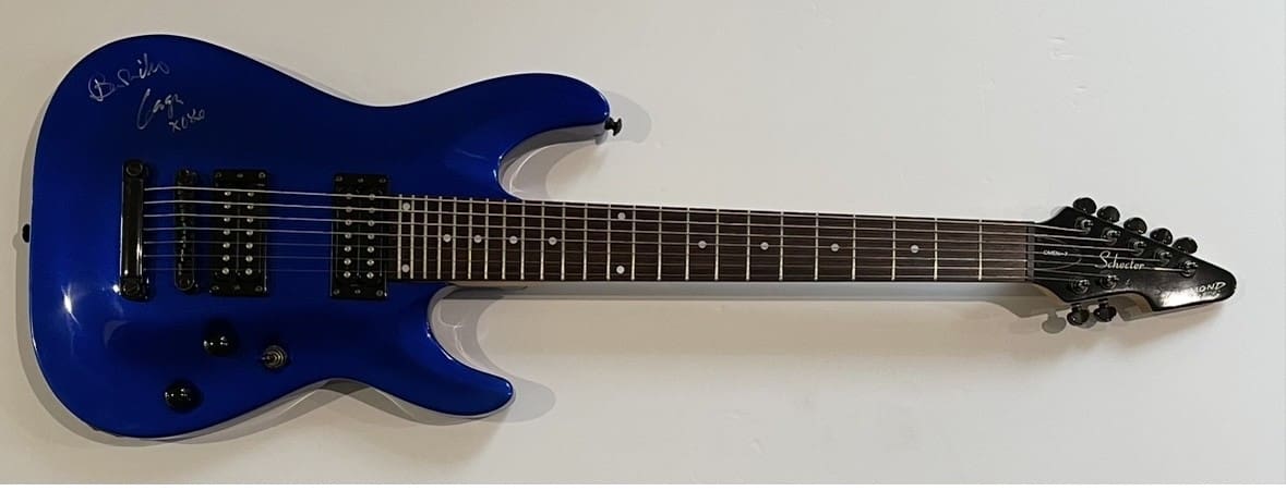 Blue electric guitar with signature on body.