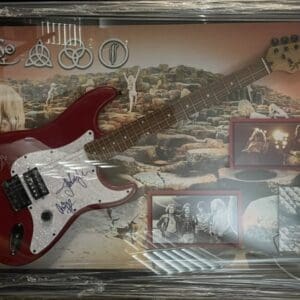Red electric guitar with band memorabilia display.