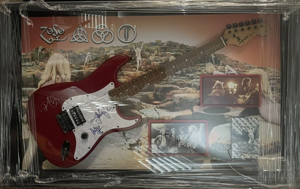 Red electric guitar with band memorabilia display.