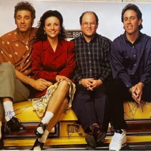 Four people sitting on a yellow taxi.