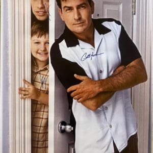 Three men posing in a doorway, smiling.