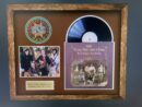 Framed album and photo of music group.