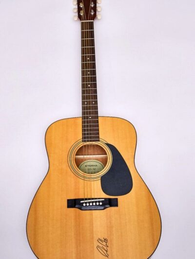 Acoustic guitar with light wood finish.