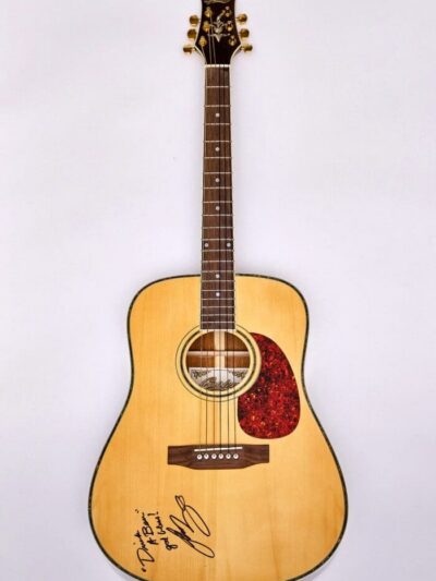 Acoustic guitar with signatures on body.