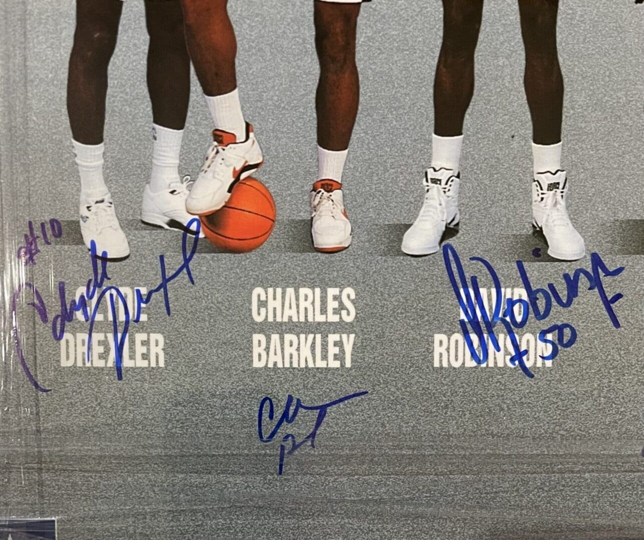Basketball players' legs with signatures and ball.