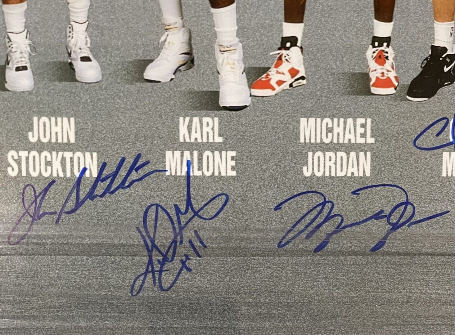 Signed basketball players' poster with shoes.