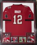 Framed red jersey with photos and signatures.
